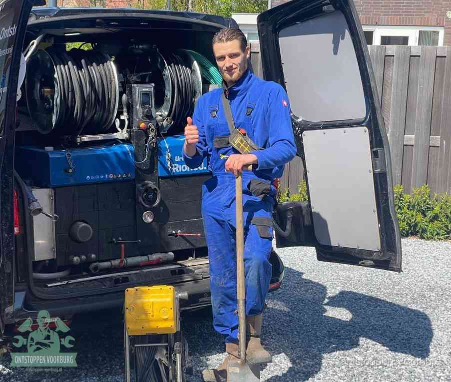Een tevreden monteur met opgestoken duim naast de bestelbus, slim ingrijpen bespaart kosten bij een verstopte afvoer in Voorburg