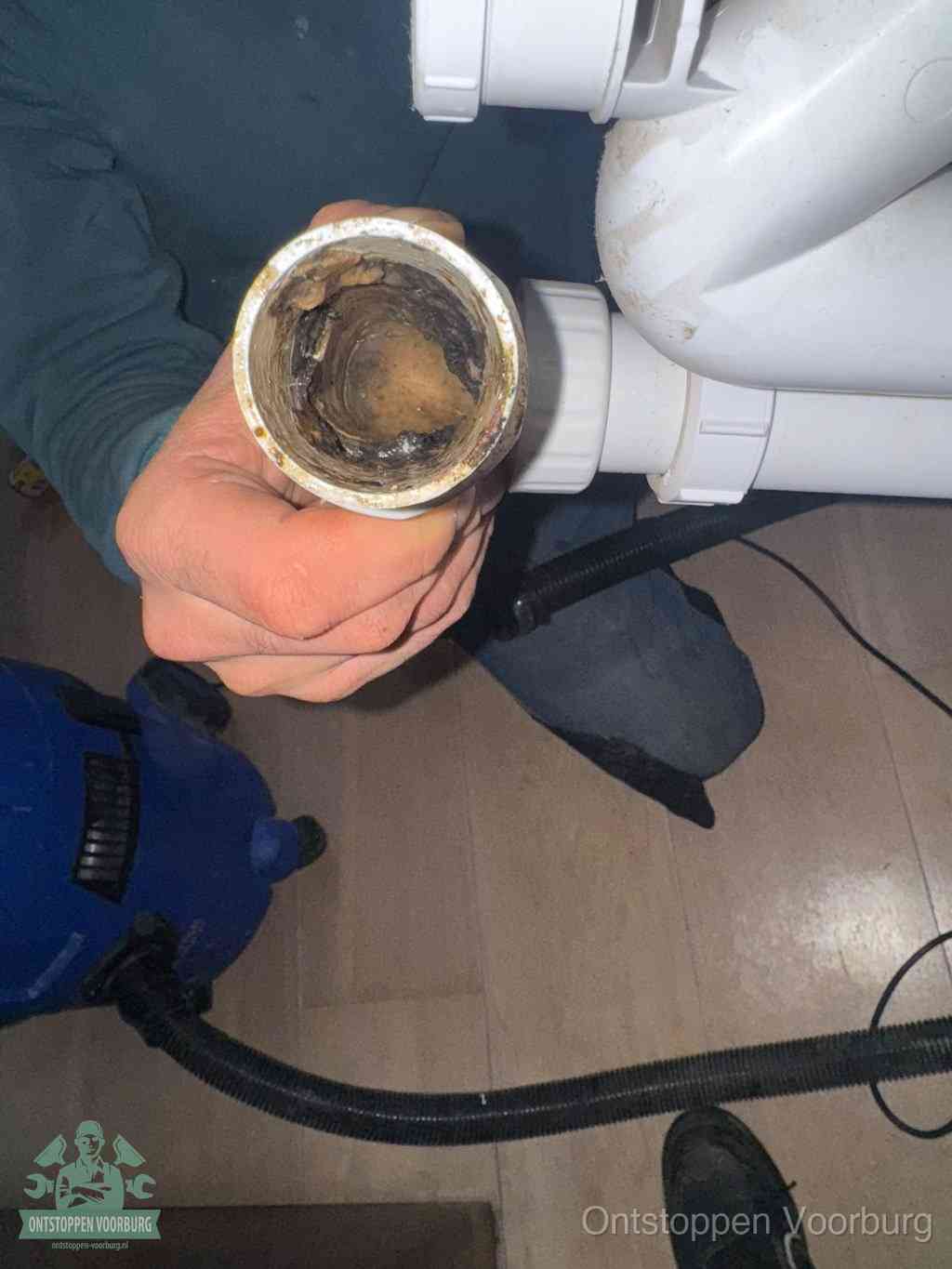 Een losgekoppeld afvoerbuisstuk dat van binnen volledig is dichtgeslibd, het gevolg van een verstopping te lang laten zitten in Voorburg