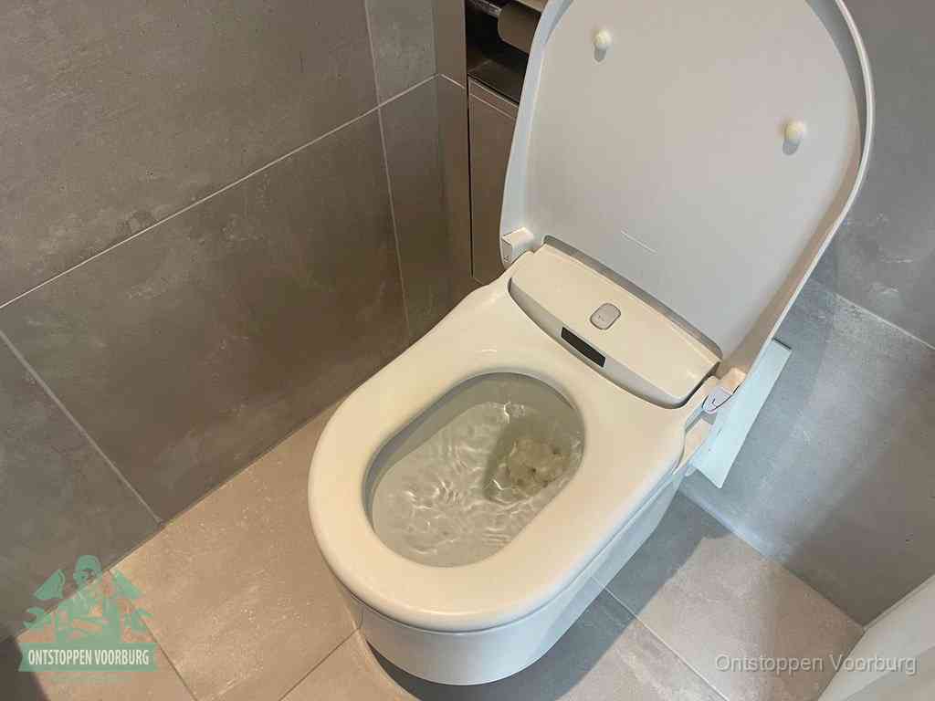 Een toiletpot vol troebel water met drijvend papier en restanten, de meest voorkomende oorzaak van een verstopte wc in Voorburg