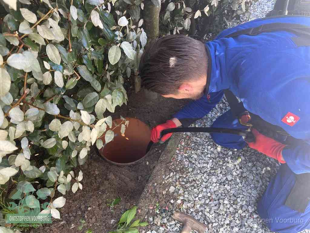 Monteur reinigt een rioolput met een slang, periodieke rioolreiniging in Voorburg