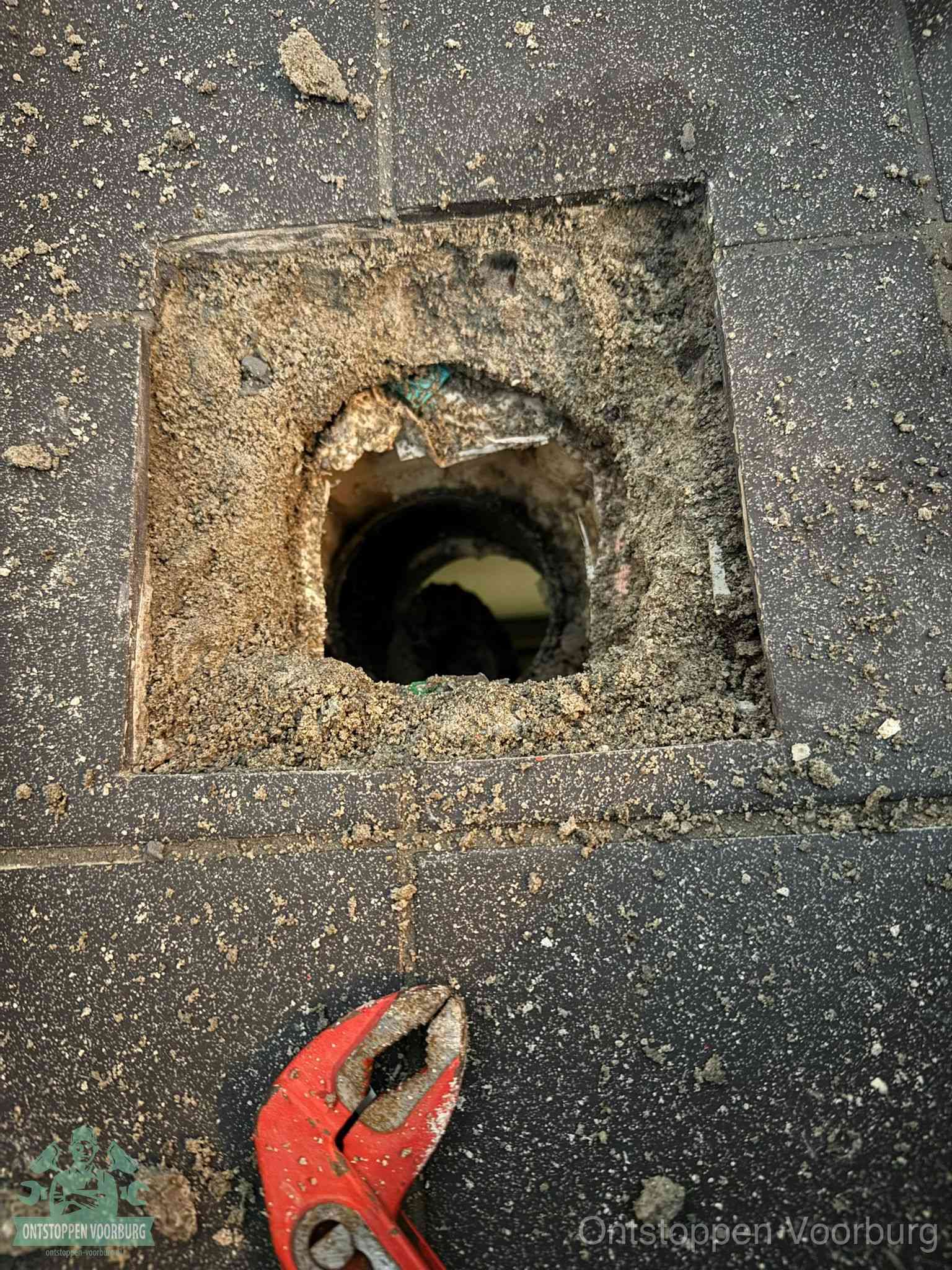 Geopend rioolputje op de erfgrens dat laat zien wie eigenaar is van de riolering in Voorburg