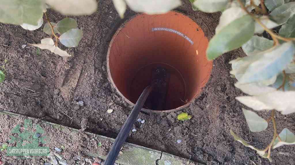 Open inspectieput in de tuin waar een veer rioolvliegjes en stankoverlast aanpakt in Voorburg