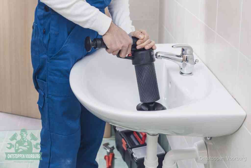 Een te ruwe doe-het-zelf poging met een hand-pomp op de afvoer van een badkamer-wastafel, een van de veelgemaakte fouten bij afvoer ontstoppen in Voorburg