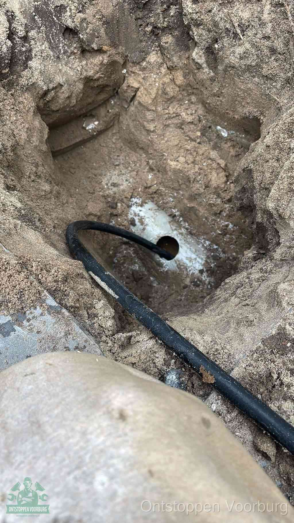 Uitgegraven rioolbuis in de grond, hulp om zelf het riool te ontstoppen in Voorburg